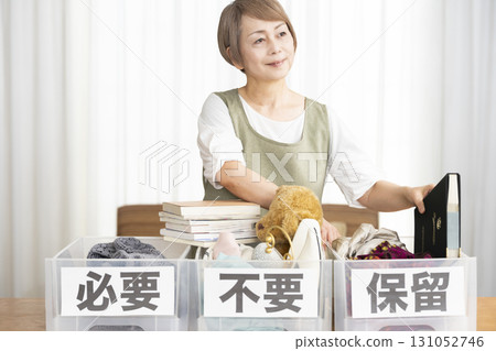 Senior woman decluttering in the living room Senior woman decluttering in the living room 131052746