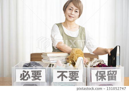 Senior woman decluttering in the living room Senior woman decluttering in the living room 131052747