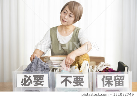 Senior woman decluttering in the living room Senior woman decluttering in the living room 131052749