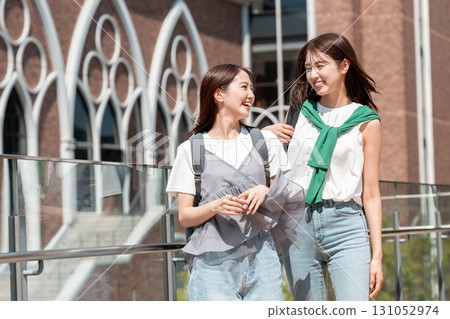 Female college students walking on university campus Female college students walking on university campus 131052974