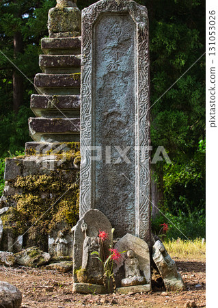 Stone pagodas, stone Buddha statues and cluster amaryllis Stone pagodas, stone Buddha statues and cluster amaryllis 131053026