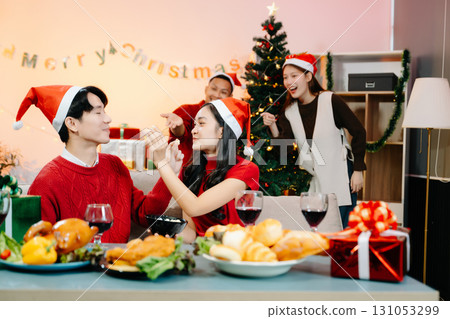 Holiday spirit with Asian friends exchanging gifts, sharing laughs, and enjoying a festive Christmas 131053299