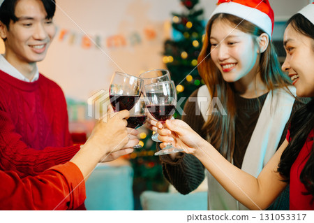 Asian friends capture the holiday spirit with gifts, laughter, and a festive Christmas dinner in a cozy, joy-filled setting 131053317