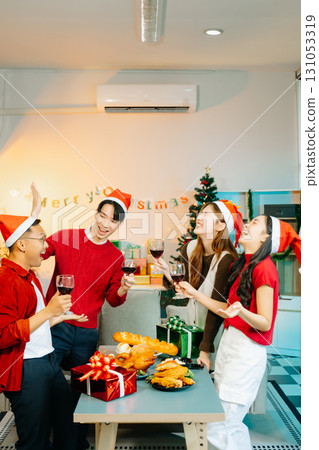 Holiday spirit with Asian friends exchanging gifts, sharing laughs, and enjoying a festive Christmas dinner 131053319