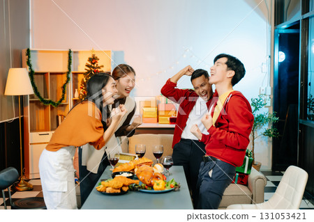 Friends celebrate Christmas with gift exchanges, festive food, and laughtera perfect scene for holiday and New Year Friends celebrate Christmas with gift exchanges, festive food, and laughtera perfect scene for holiday and New Year 131053421