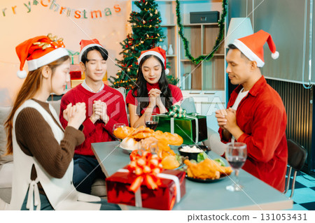 Holiday spirit with Asian friends exchanging gifts, sharing laughs, and enjoying a festive Christmas dinner 131053431