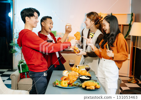 Friends celebrate Christmas with gift exchanges, festive food, and laughtera perfect scene for holiday and New Year 131053463