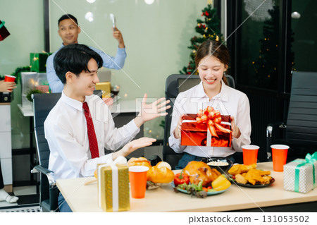 Celebrate Christmas with colleagues in a joyful office party setting, sharing gifts, laughs, and holiday 131053502
