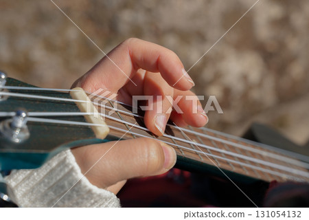 Close up of female hands playing guitar ukulele and singing relaxing enjoying outdoors on sunny autumn day. Hippie woman in boho style training playing musical instrument. Fall leaves Close up of female hands playing guitar ukulele and singing relaxing enjoying outdoors on sunny autumn day. Hippie woman in boho style training playing musical instrument. Fall leaves 131054132