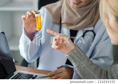 Female healthcare professional discussing medication with a patient, showcasing inclusivity in medical practice. Female healthcare professional discussing medication with a patient, showcasing inclusivity in medical practice. 131054155