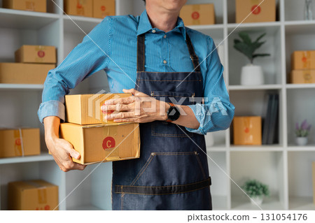 Entrepreneur carrying stacked packages for online business, showcasing the hands-on nature of startup logistics. Entrepreneur carrying stacked packages for online business, showcasing the hands-on nature of startup logistics. 131054176