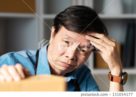 Entrepreneur reflecting on challenges while managing online business operations with packages. Entrepreneur reflecting on challenges while managing online business operations with packages. 131054177