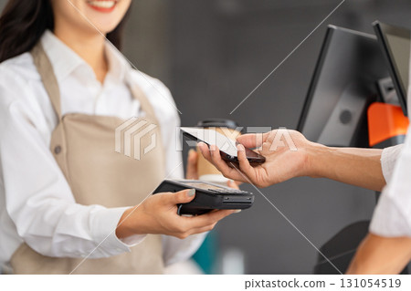 Customer making payment with smartphone at a cafe checkout 131054519