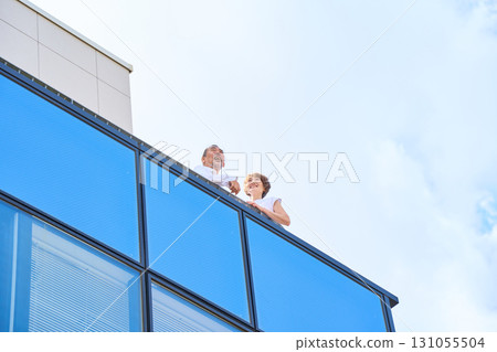 A middle-aged couple standing on the balcony. A middle-aged couple standing on the balcony. 131055504