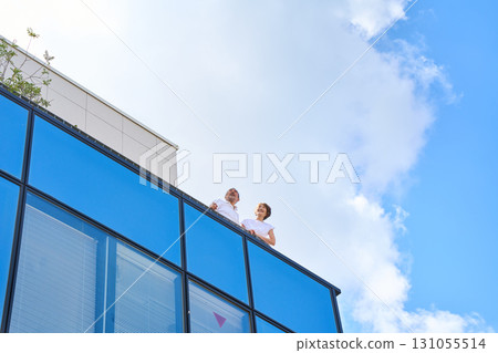 A middle-aged couple standing on the balcony. A middle-aged couple standing on the balcony. 131055514
