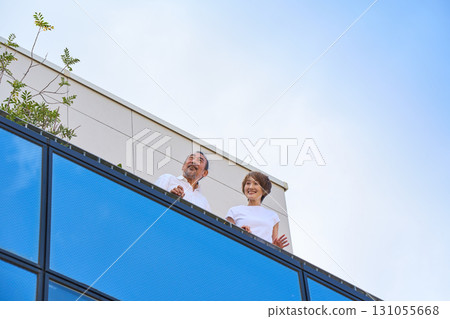 A middle-aged couple standing on the balcony. A middle-aged couple standing on the balcony. 131055668