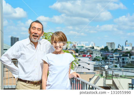 一對富有的中年夫婦站在陽台上 131055990