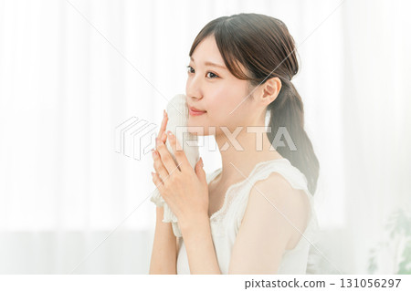 Young Asian woman washing her face and drying it with a towel (face wash) Young Asian woman washing her face and drying it with a towel (face wash) 131056297