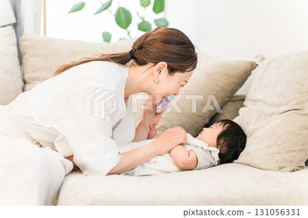 A young Asian woman soothing a baby on the sofa (mother, childcare, parenting) A young Asian woman soothing a baby on the sofa (mother, childcare, parenting) 131056331