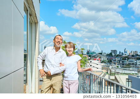 A middle-aged couple standing on the balcony. 131056403