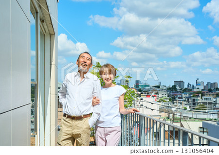 A middle-aged couple standing on the balcony. A middle-aged couple standing on the balcony. 131056404