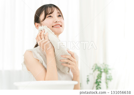 年輕的亞洲女人洗臉並用毛巾擦乾（洗臉） 131056638