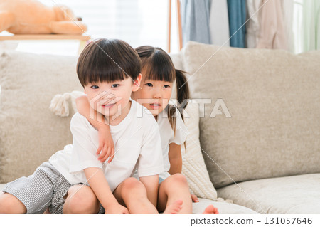 A close brother and sister on the sofa in the living room A close brother and sister on the sofa in the living room 131057646
