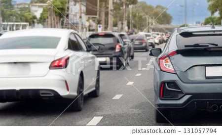 Rear side of car on the road. Traffic from many car driving on the asphalt road. Traffic jam in the city with row of cars on the road. Blurred of trees in the city undery blue sky. Rear side of car on the road. Traffic from many car driving on the asphalt road. Traffic jam in the city with row of cars on the road. Blurred of trees in the city undery blue sky. 131057794