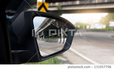 Mirror view from the side of the car can see the bridge and the road. Light shot straight into the middle of the asphalt road. Road curves along the side of the route. Mirror view from the side of the car can see the bridge and the road. Light shot straight into the middle of the asphalt road. Road curves along the side of the route. 131057796