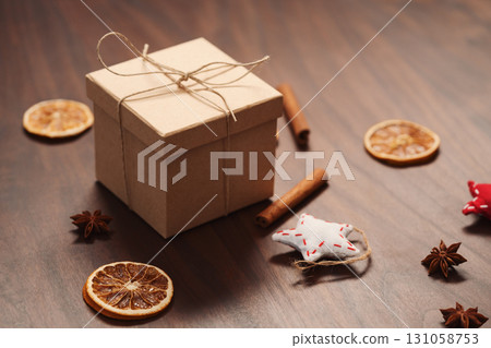 Christmas gift box from eco friendly paper wrapped with natural twine on wood table with natural decorations Christmas gift box from eco friendly paper wrapped with natural twine on wood table with natural decorations 131058753