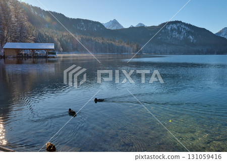 Serene Winter Wonderland: Frozen Lake Reflects Snow-Capped Mountains in Golden Morning Light Pristine Icy Landscape Captures Breathtaking Beauty of Alpine Lake on Crisp Sunny Day Serene Winter Wonderland: Frozen Lake Reflects Snow-Capped Mountains in Golden Morning Light Pristine Icy Landscape Captures Breathtaking Beauty of Alpine Lake on Crisp Sunny Day 131059416