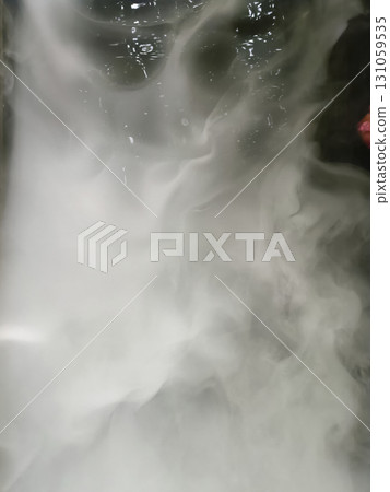 Image shows swirling white smoke or vapor with dark background, creating mysterious and ethereal atmosphere. smoke appears dense and flowing, with some reflections visible on surface Image shows swirling white smoke or vapor with dark background, creating mysterious and ethereal atmosphere. smoke appears dense and flowing, with some reflections visible on surface 131059535