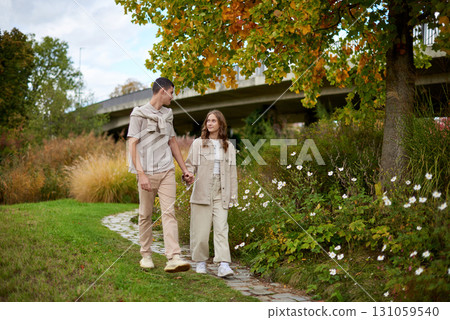 Young Cute Female Hugs Boyfriend. In Autumn Outdoor. Lovers Walking in Park. Attractive Funny Couple. Lovestory in Forest. Man and Woman. Cute Lovers in the Park. Family Concept. Happy Couple. 131059540