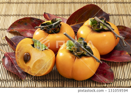 Autumn persimmon fruit with red leaves 131059594