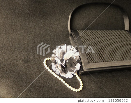 黑色袋子背景上的珍珠和胸花 黑色袋子背景上的珍珠和胸花 131059932