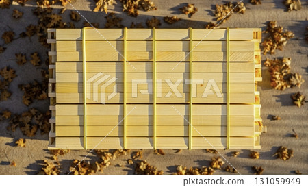Stacked wooden planks with yellow straps surrounded by autumn leaves at sunset 131059949