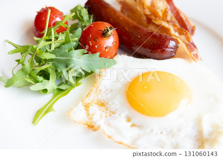 Delicious breakfast of fried eggs, bacon, sausage and grilled tomatoes 131060143