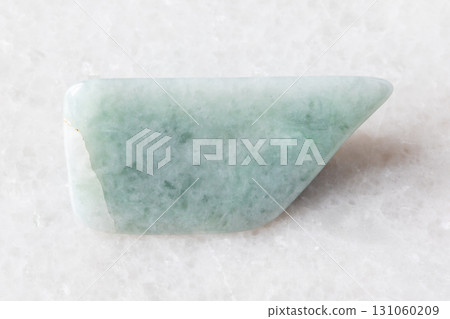 sample of polished jadeite mineral on white marble sample of polished jadeite mineral on white marble 131060209
