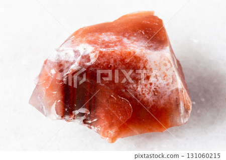 raw carneol chalcedony mineral on white marble 131060215