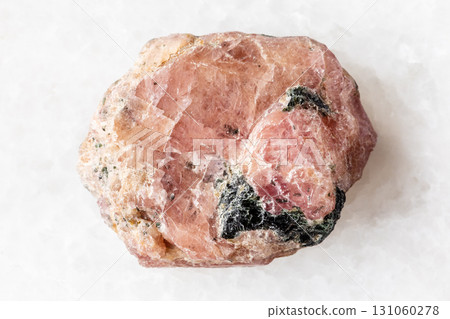 sample of raw pink ruby mineral on white marble 131060278