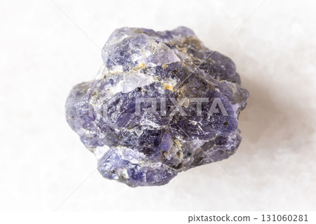 sample of raw iolite mineral on white marble 131060281