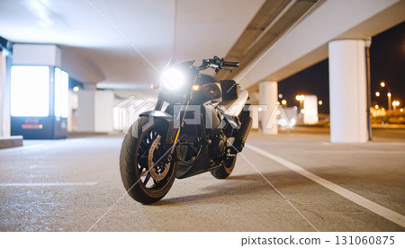 Sleek Motorcycle Parked Under Urban Overpass at Night 131060875