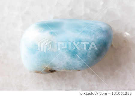 sample of tumbled larimar mineral on white marble 131061233