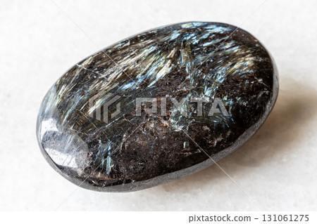 sample of polished nuummite stone on white marble 131061275