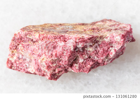 sample of raw thulite rock on white marble 131061280