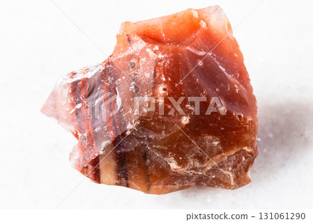 raw carneol chalcedony rock on white marble raw carneol chalcedony rock on white marble 131061290