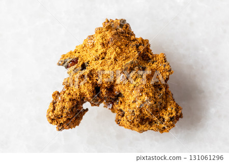 sample of raw wulfenite ore on white marble 131061296