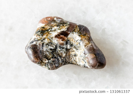 sample of uncut andalusite mineral on white marble 131061337