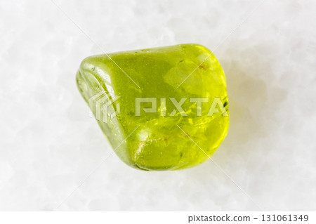 sample of polished peridod crystal on white marble 131061349
