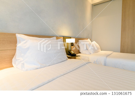 A double bed covered with white sheds in a beautiful bedroom. 131061675